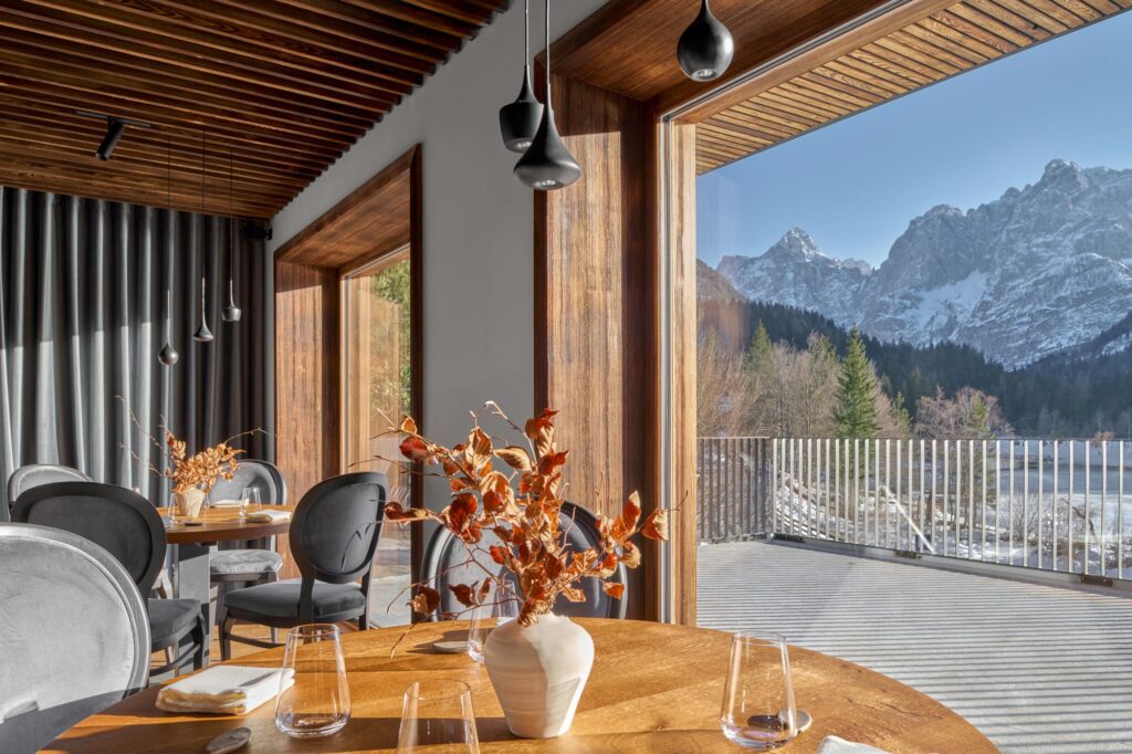 Restaurant wooden tables with large windows overlooking the mountains in Slovenia
