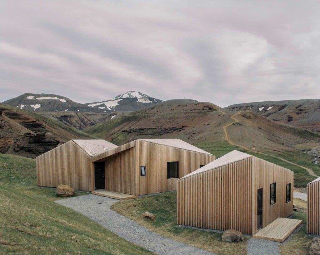 Wooden modern architecture cabins with snowy mountains in the Highlands if Iceland