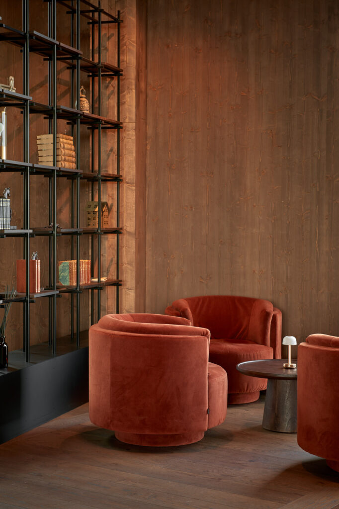 Red couch in a lounge area with bookshelves